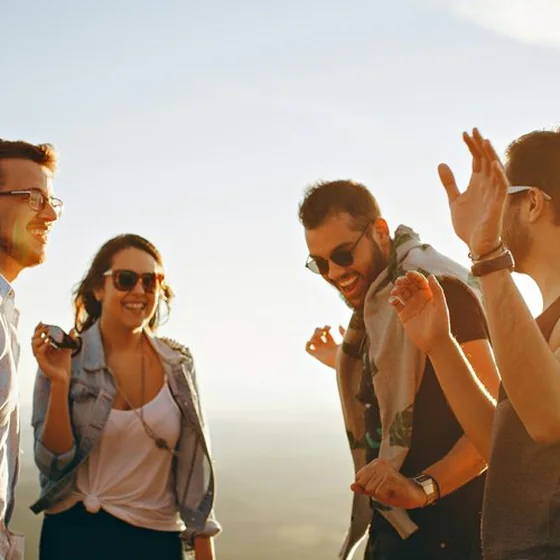 Friends laughing together outdoors at sunset